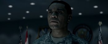 Movie still from “Man of Steel” (2013), directed by Zack Snyder – A man in fatigues is looking into the distance; Close Up shot, Low angle