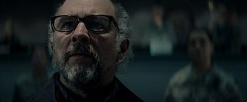 Movie still from “Man of Steel” (2013), directed by Zack Snyder – A person with a beard wearing glasses; Close Up shot, Low angle