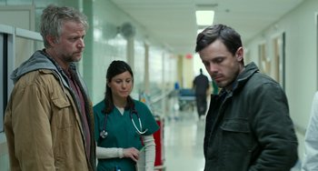 Movie still from “Manchester by the Sea” (2016), directed by Kenneth Lonergan – Two men and a woman in a hospital hallway; Medium shot, Low angle