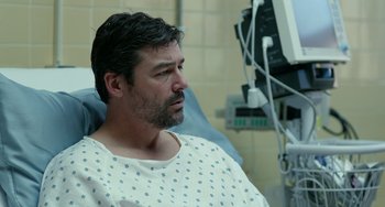 Movie still from “Manchester by the Sea” (2016), directed by Kenneth Lonergan – A man sitting in a hospital bed looking at the camera; Close Up shot, Over the shoulder angle