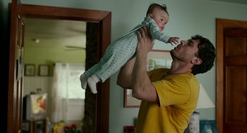 Movie still from “Manchester by the Sea” (2016), directed by Kenneth Lonergan – A man holding a baby in his arms; Medium shot, Low angle