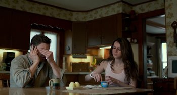 Movie still from “Manchester by the Sea” (2016), directed by Kenneth Lonergan – A man and a woman sitting at a kitchen table; Medium shot, Low angle