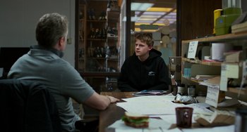 Movie still from “Manchester by the Sea” (2016), directed by Kenneth Lonergan – A man sitting at a table talking to another man; Medium shot, Over the shoulder angle