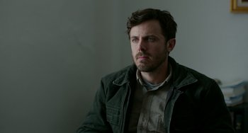 Movie still from “Manchester by the Sea” (2016), directed by Kenneth Lonergan – A person sitting in a chair; Close Up shot, Over the shoulder angle
