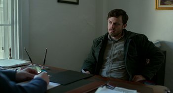 Movie still from “Manchester by the Sea” (2016), directed by Kenneth Lonergan – A man sitting at a table in front of another man; Medium shot, Over the shoulder angle