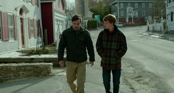 Movie still from “Manchester by the Sea” (2016), directed by Kenneth Lonergan – Two men walking down the street talking to each other; Medium shot, Over the shoulder angle