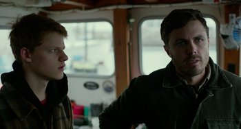 Movie still from “Manchester by the Sea” (2016), directed by Kenneth Lonergan – Two people standing next to each other on a boat; Medium shot, Over the shoulder angle