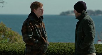 Movie still from “Manchester by the Sea” (2016), directed by Kenneth Lonergan – Two men standing next to each other near the ocean; Medium shot, Over the shoulder angle