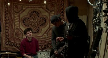 Movie still from “Manchester by the Sea” (2016), directed by Kenneth Lonergan – A group of young men playing instruments in a room; Medium shot, Low angle