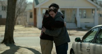 Movie still from “Manchester by the Sea” (2016), directed by Kenneth Lonergan – Two people hugging in front of a house; Medium shot, Over the shoulder angle
