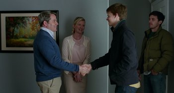 Movie still from “Manchester by the Sea” (2016), directed by Kenneth Lonergan – Two men and a woman shaking hands in a room; Medium shot, Over the shoulder angle