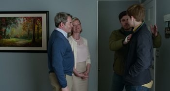 Movie still from “Manchester by the Sea” (2016), directed by Kenneth Lonergan – A man taking a picture of a woman and a man standing next to each other; Medium shot, Over the shoulder angle