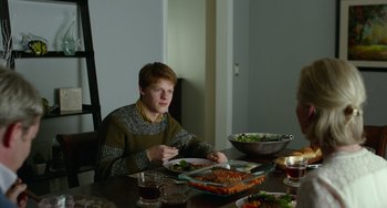 Movie still from “Manchester by the Sea” (2016), directed by Kenneth Lonergan – A man sitting at a table with a plate of food in front of him; Medium shot, Over the shoulder angle