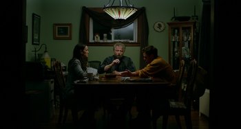 Movie still from “Manchester by the Sea” (2016), directed by Kenneth Lonergan – A group of people sitting at a dinner table; Medium shot, Over the shoulder angle