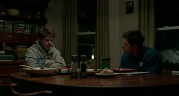 Movie still from “Manchester by the Sea” (2016), directed by Kenneth Lonergan – Two men sitting at a dinner table having a conversation; Medium shot, Over the shoulder angle