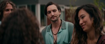 Movie still from “Margaux” (2022), directed by Steven C. Miller – A person with long hair and a beard; Close Up shot, Over the shoulder angle