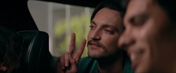 Movie still from “Margaux” (2022), directed by Steven C. Miller – A person with long black hair wearing a green shirt; Close Up shot, Over the shoulder angle