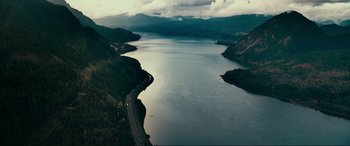 Movie still from “Margaux” (2022), directed by Steven C. Miller – An aerial view of a body of water with a highway going through it; Extreme Wide shot, High angle