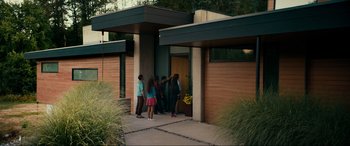 Movie still from “Margaux” (2022), directed by Steven C. Miller – A group of people standing in front of a building; Wide shot, High angle