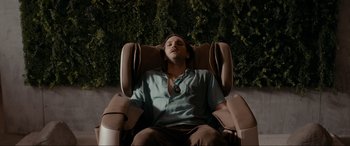Movie still from “Margaux” (2022), directed by Steven C. Miller – A man sitting in a reclining chair with his eyes closed; Medium shot, Overhead angle