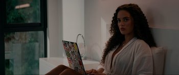 Movie still from “Margaux” (2022), directed by Steven C. Miller – A woman sitting in front of a laptop computer; Medium shot, Over the shoulder angle