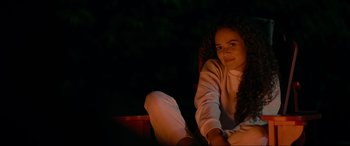 Movie still from “Margaux” (2022), directed by Steven C. Miller – A woman sitting on a chair in the dark; Medium shot, Over the shoulder angle