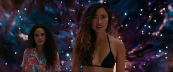 Movie still from “Margaux” (2022), directed by Steven C. Miller – A woman in a black bikini standing in front of some lights; Medium shot, Over the shoulder angle