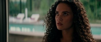 Movie still from “Margaux” (2022), directed by Steven C. Miller – A person with long curly hair; Close Up shot, Over the shoulder angle