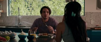 Movie still from “Margaux” (2022), directed by Steven C. Miller – A man sitting at a table with a plate of food; Medium shot, Over the shoulder angle