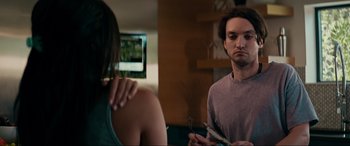 Movie still from “Margaux” (2022), directed by Steven C. Miller – A man and a woman are looking at each other in a living room; Medium shot, Over the shoulder angle