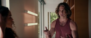 Movie still from “Margaux” (2022), directed by Steven C. Miller – A man standing in front of a window with his hand outstretched; Medium shot, Over the shoulder angle