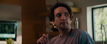 Movie still from “Margaux” (2022), directed by Steven C. Miller – A man holding a fork with food on it; Close Up shot, Over the shoulder angle