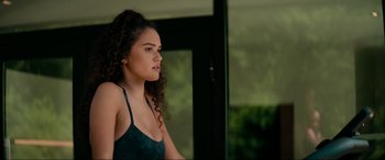 Movie still from “Margaux” (2022), directed by Steven C. Miller – A woman with curly brown hair wearing a green top; Medium shot, Over the shoulder angle