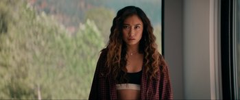 Movie still from “Margaux” (2022), directed by Steven C. Miller – A woman with long curly brown hair wearing a plaid shirt; Medium shot, Low angle