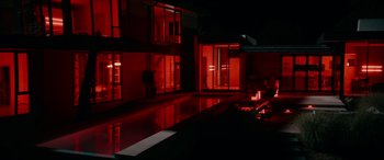 Movie still from “Margaux” (2022), directed by Steven C. Miller – A pool in the middle of a house lit up at night; Extreme Wide shot, Low angle