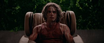 Movie still from “Margaux” (2022), directed by Steven C. Miller – A man sitting in a chair with his eyes closed; Medium shot, High angle