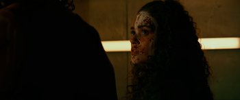 Movie still from “Margaux” (2022), directed by Steven C. Miller – A young woman with makeup on her face looking into a mirror; Close Up shot, Over the shoulder angle