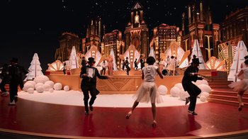A group of people dancing on a stage in front of an audience