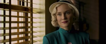 Movie still from “Marlowe” (2022), directed by Neil Jordan – A woman in a green dress and a white hat; Close Up shot, Low angle