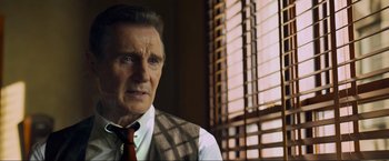 Movie still from “Marlowe” (2022), directed by Neil Jordan – An older man wearing a vest and a tie; Close Up shot, Low angle