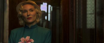 Movie still from “Marlowe” (2022), directed by Neil Jordan – A woman in a green dress holding a pink flower; Close Up shot, Low angle