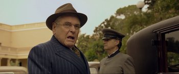 Movie still from “Marlowe” (2022), directed by Neil Jordan – A man in a suit and a man in a hat; Close Up shot, Over the shoulder angle