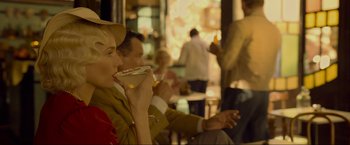 Movie still from “Marlowe” (2022), directed by Neil Jordan – A group of people sitting at a table eating food; Medium shot, Over the shoulder angle