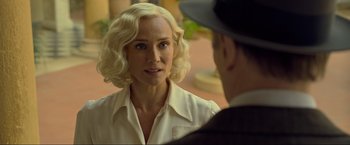 Movie still from “Marlowe” (2022), directed by Neil Jordan – A woman in a white shirt and a man in a suit; Close Up shot, Over the shoulder angle