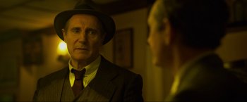 Movie still from “Marlowe” (2022), directed by Neil Jordan – An older man wearing a suit and a hat looking at himself in the mirror; Close Up shot, Over the shoulder angle