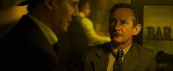 Movie still from “Marlowe” (2022), directed by Neil Jordan – A man in a suit and tie looking at a man in a tie; Close Up shot, Over the shoulder angle