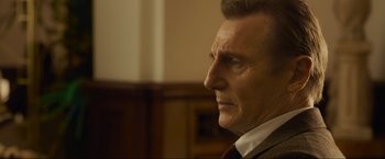 Movie still from “Marlowe” (2022), directed by Neil Jordan – A person wearing a suit and tie; Close Up shot, Low angle