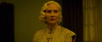 Movie still from “Marlowe” (2022), directed by Neil Jordan – A woman with blonde curly hair wearing a dress; Close Up shot, Low angle