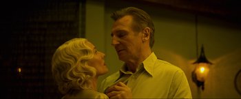 Movie still from “Marlowe” (2022), directed by Neil Jordan – An older man and a younger woman looking at each other; Close Up shot, Low angle