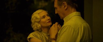 Movie still from “Marlowe” (2022), directed by Neil Jordan – An older man and a younger woman holding hands; Close Up shot, High angle